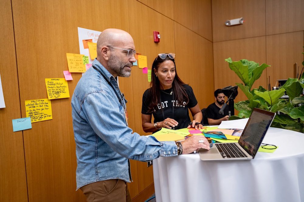 A man and woman looking at a laptop.